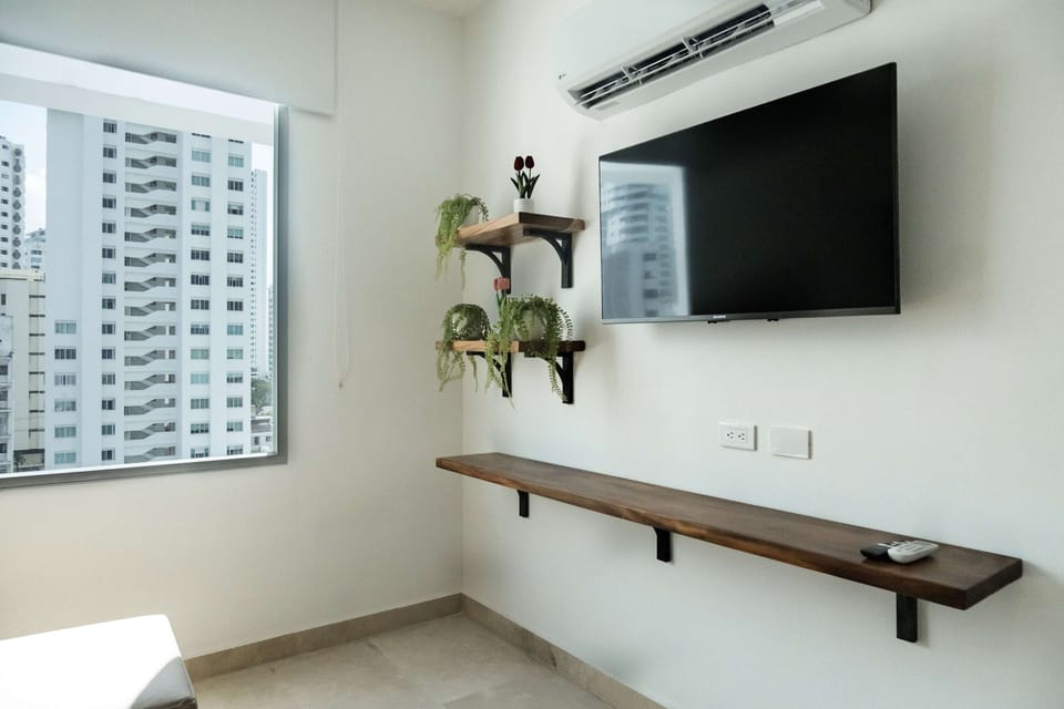 Wall-mounted TV with floating shelf.