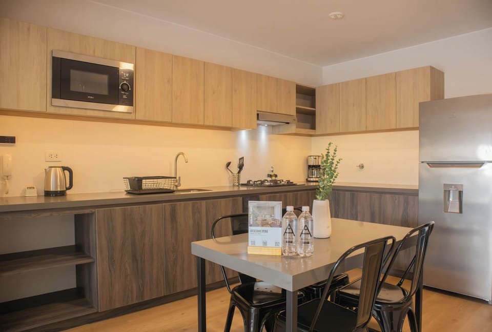 A fully equipped kitchen with light wood finishes and a dining area