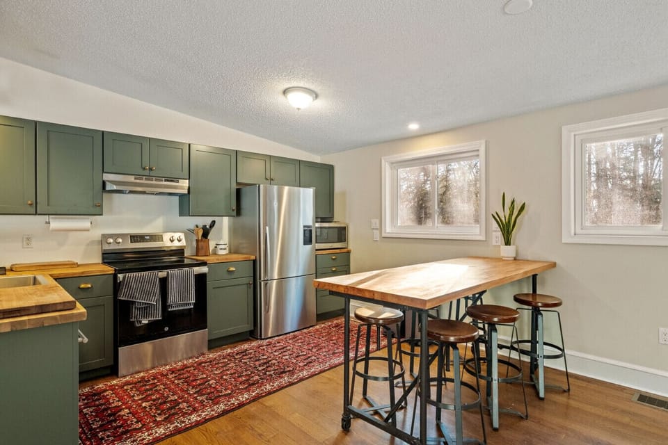 Fully equipped kitchen featuring bar seating and woodland views