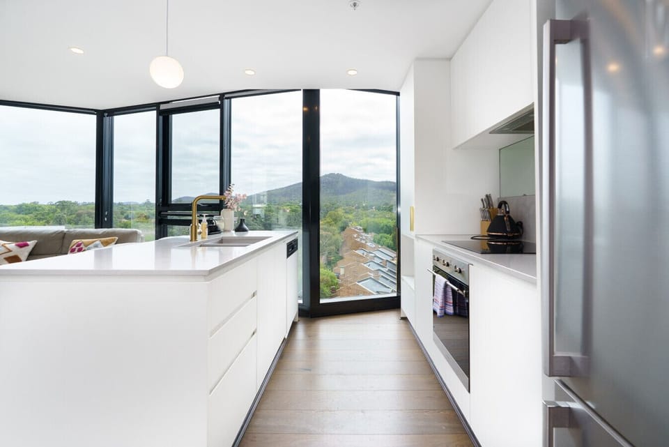 Cook and gather in this light-filled kitchen with a spacious island bench. Perfect for easy meals while enjoying the view outside.