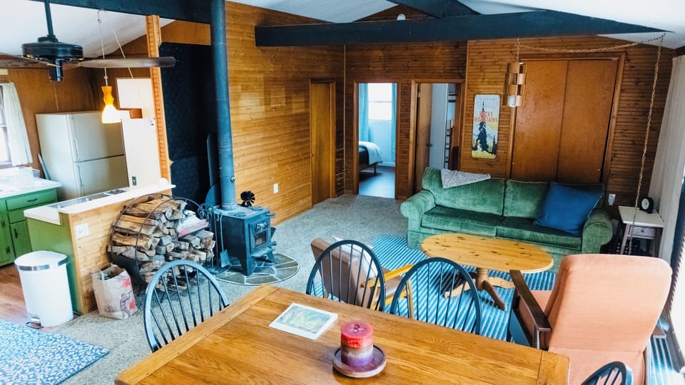 Open living and dining area with cozy seating and forest views