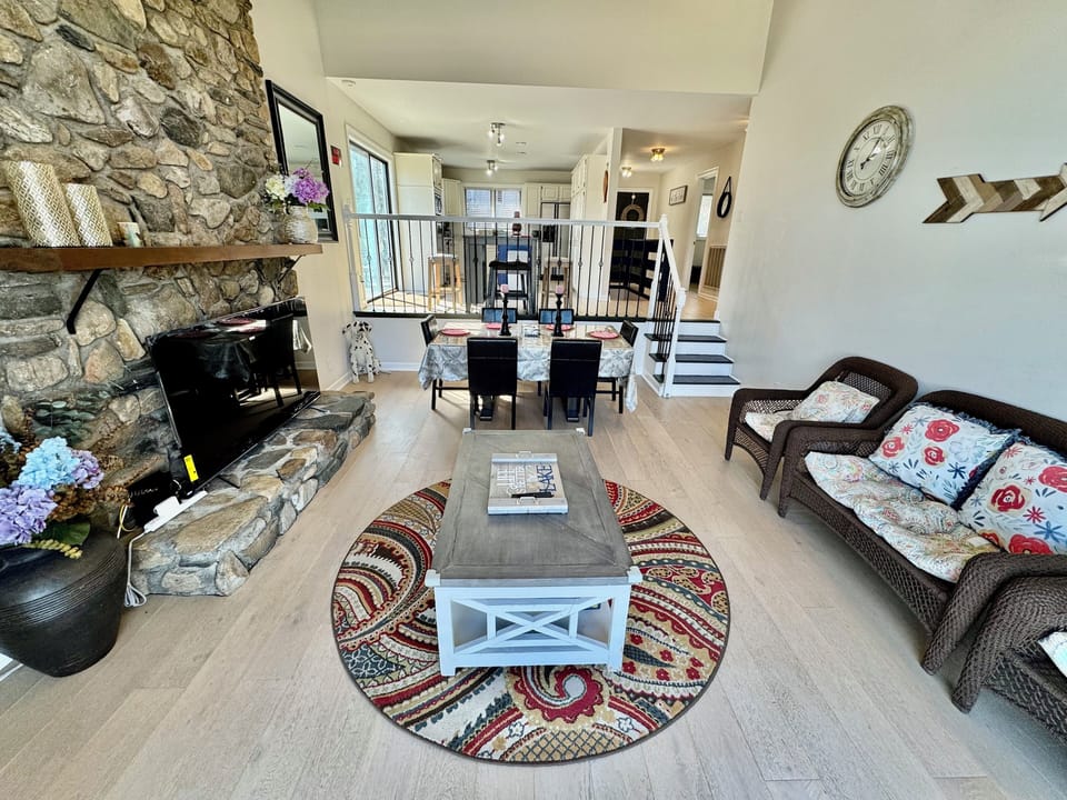 1st Living room: a 65' smart TV, sofa chairs, a dinning table, & access to deck 