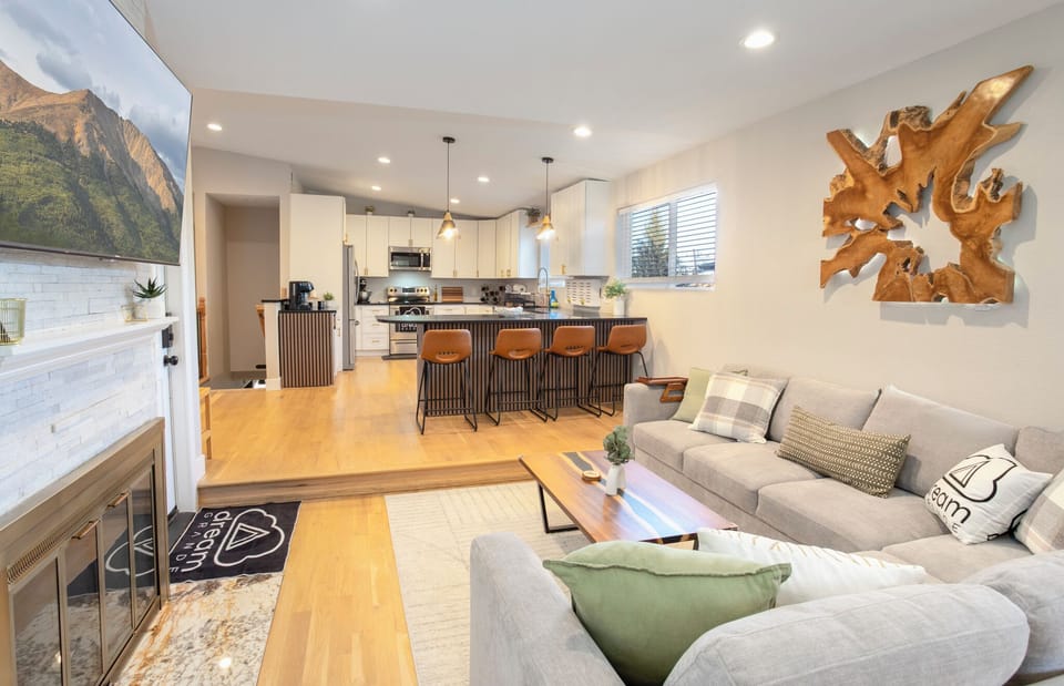 Modern living room with large sectional, smart TV, and contemporary art