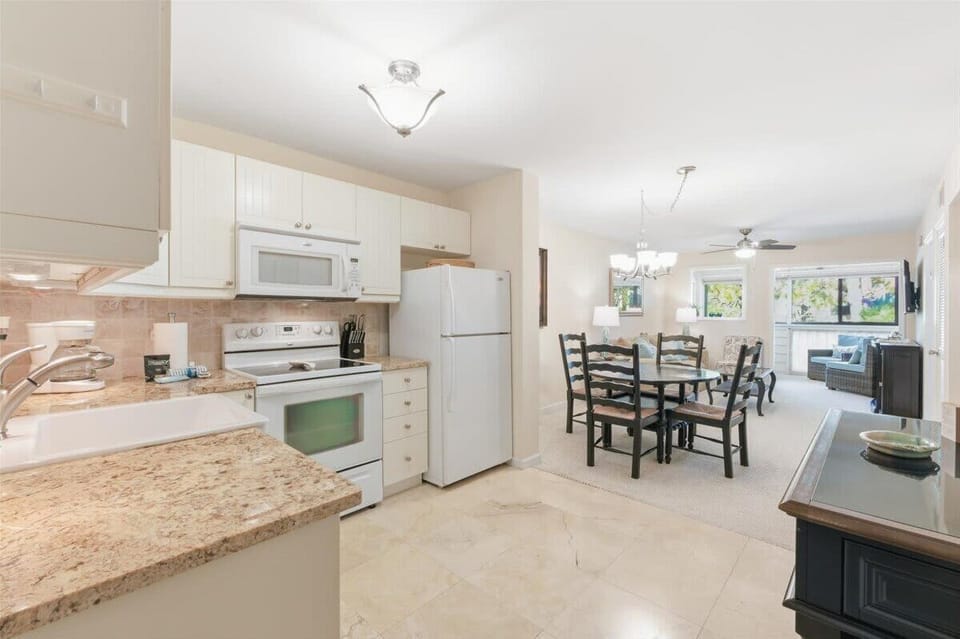 Fully equipped kitchen with modern appliances, ample counter space, and a dining breakfast bar.