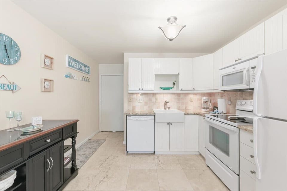 Fully equipped kitchen with modern appliances, ample counter space, and a dining breakfast bar.