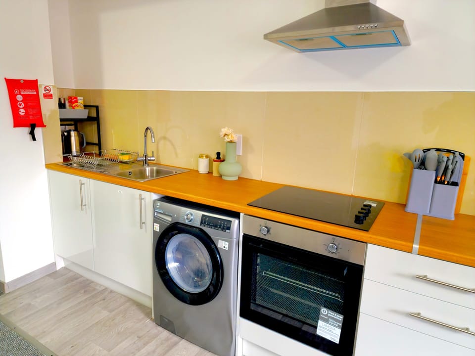 Sleek, fully equipped kitchenette with oven, cooktop & washer/dryer.