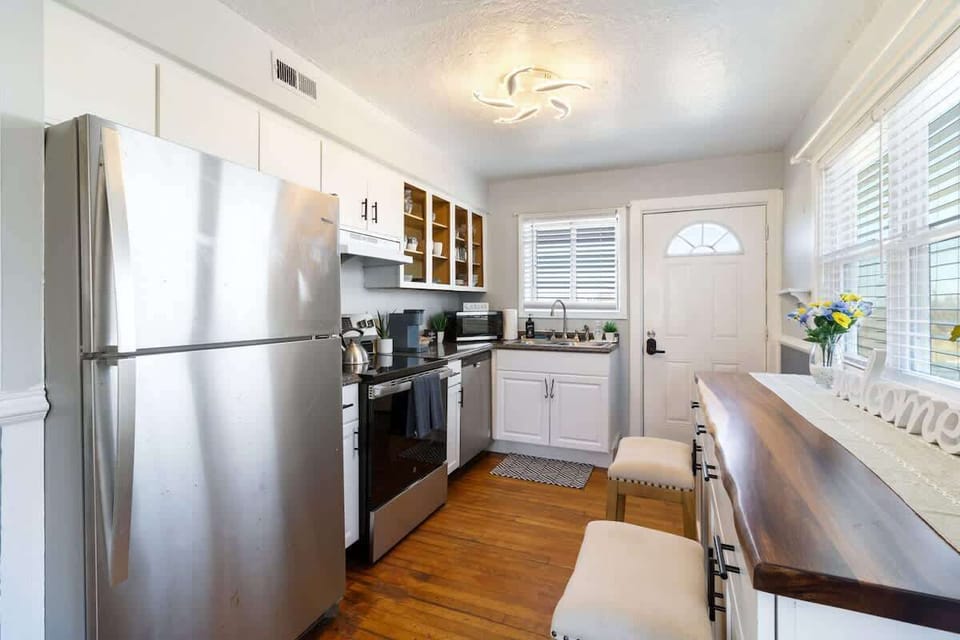 Stainless steel appliances and bright cabinetry define this compact, functional kitchen. The space looks clean and well-organized.
