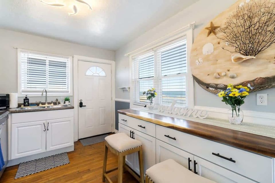 Bathroom w/ white vanity, wide counter & plenty of natural light