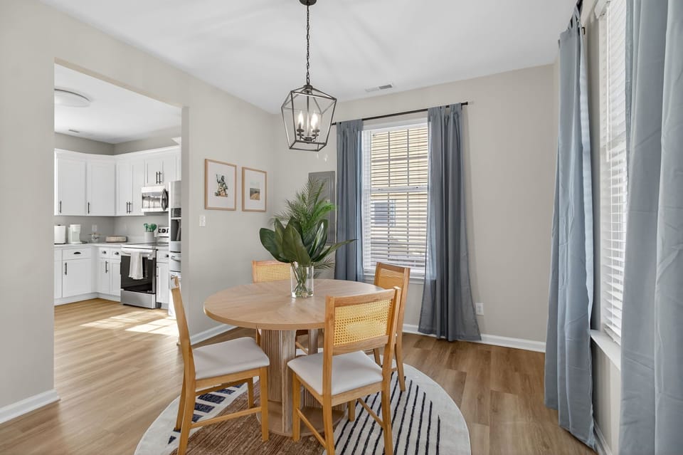 Cozy dining nook w/ wooden table set beside sunlit windows