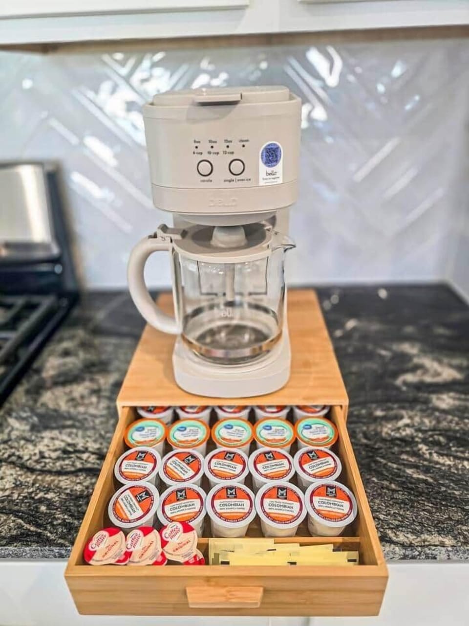 Coffee station with a drip coffee maker and a variety of coffee pods, creamers, and sweeteners—perfect for an easy morning or afternoon pick-me-up.