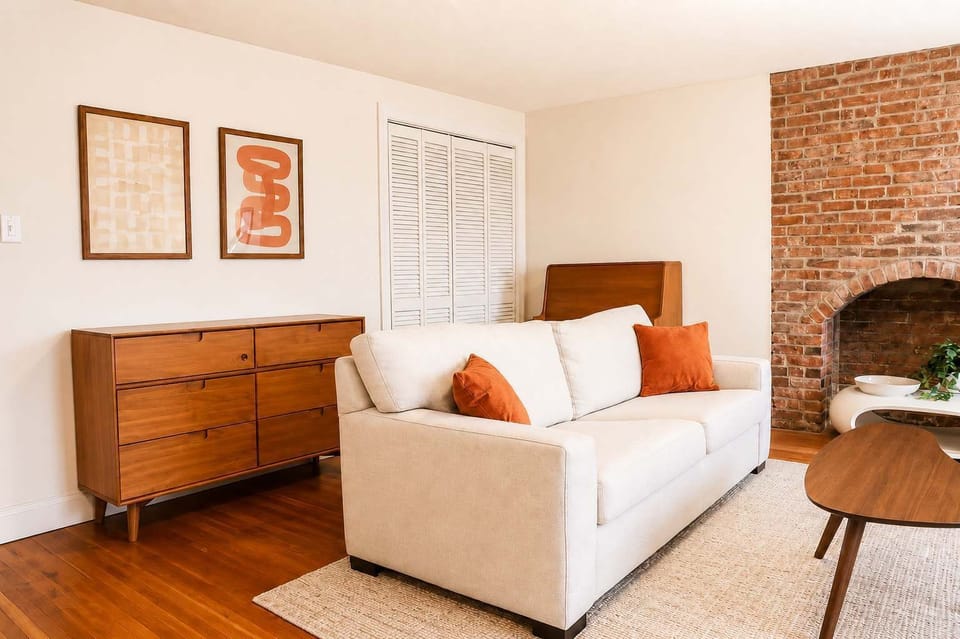Inviting living space with comfortable seating and charming character details, including an exposed brick fireplace feature that adds warmth and personality to the room.