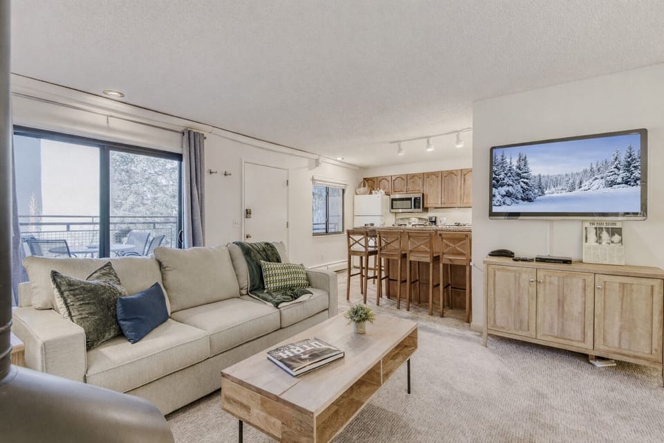Settle into your cozy living space with plush seating and mountain views, where rustic charm meets modern comfort for your perfect retreat.