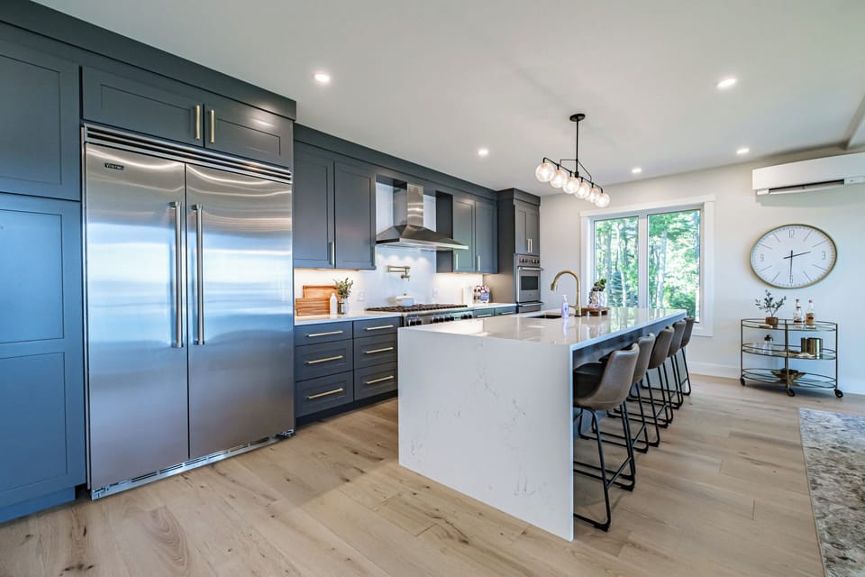 Kitchen featuring Viking appliances and an island with six barstools. 