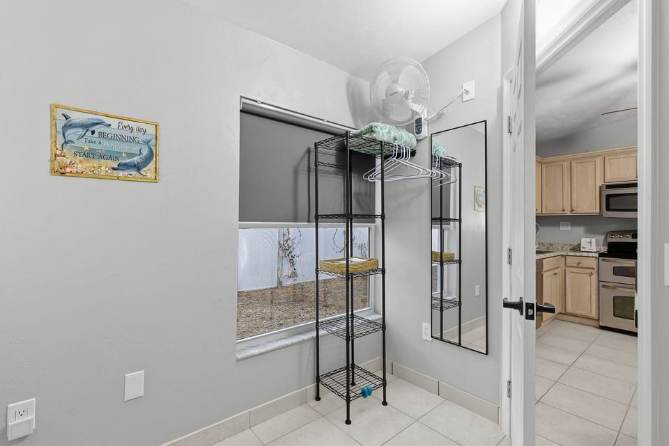 Convenient beach stay storage area with shelving, hanging space, and mirror—perfect for organizing your beach gear and getting ready for a relaxing day by the shore.