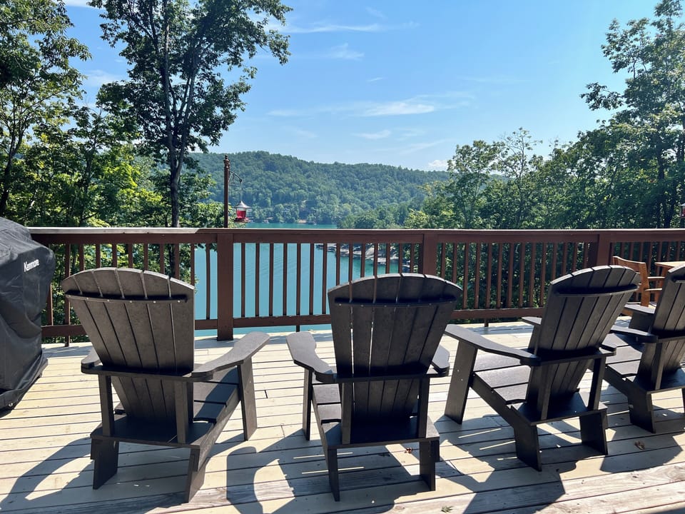 Upper level deck with lounge chairs and dining table and stunning views