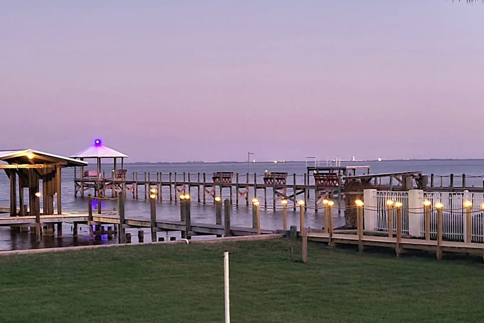 Stroll the boardwalk at dusk as solar post lights lead the way to the water. Enjoy panoramic views of the lagoon and the iconic NASA assembly building glowing on the skyline—a truly tranquil path from the pool to your private dock