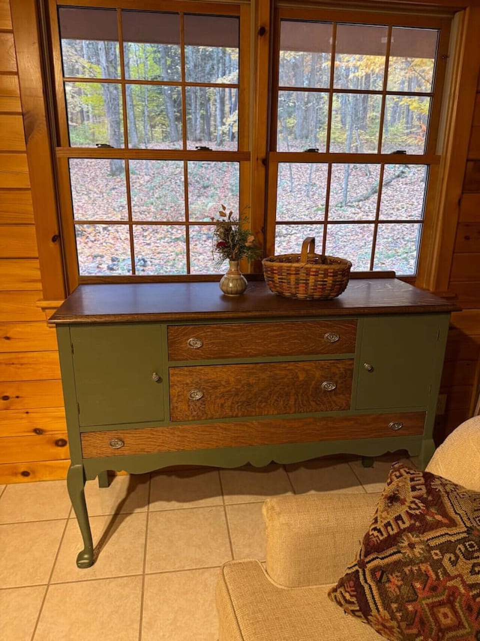 Adirondack-style living room with warm wood accents, comfortable seating, and large windows overlooking the 30-acre property. Newly renovated space