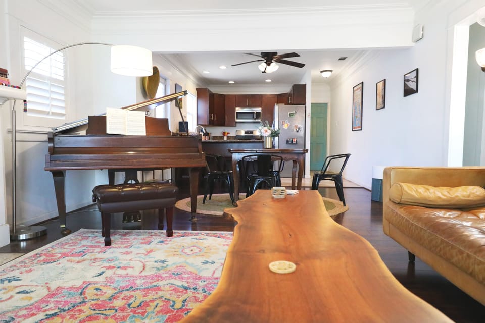 Open floor living and dining feature a grand piano, television, and board games.