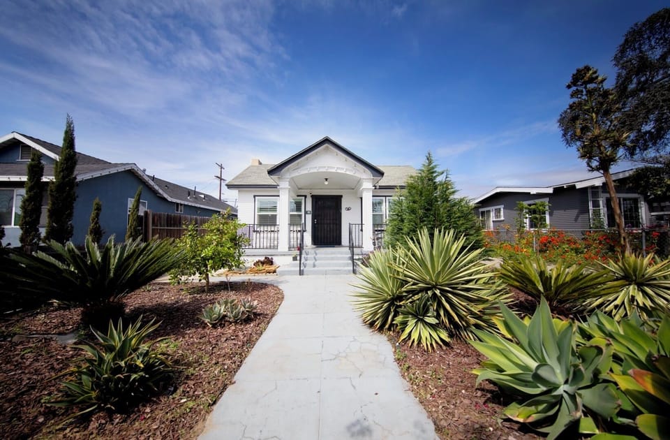 The garden approaching the front door features succulents and fruit trees.