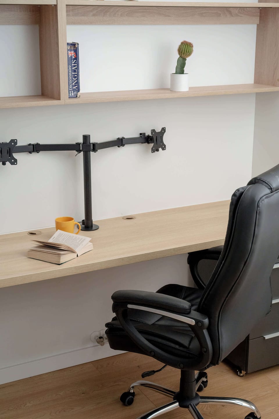 A closer view of the workspace showing the desk and shelving. Minimal decor keeps the area uncluttered. The setup looks ideal for remote work.
