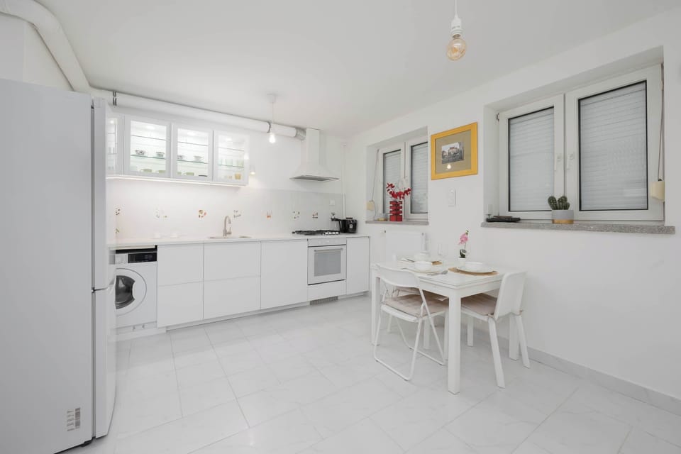 A modern kitchen with white cabinets, a gas stove, oven, and dishwasher, perfect for preparing meals.