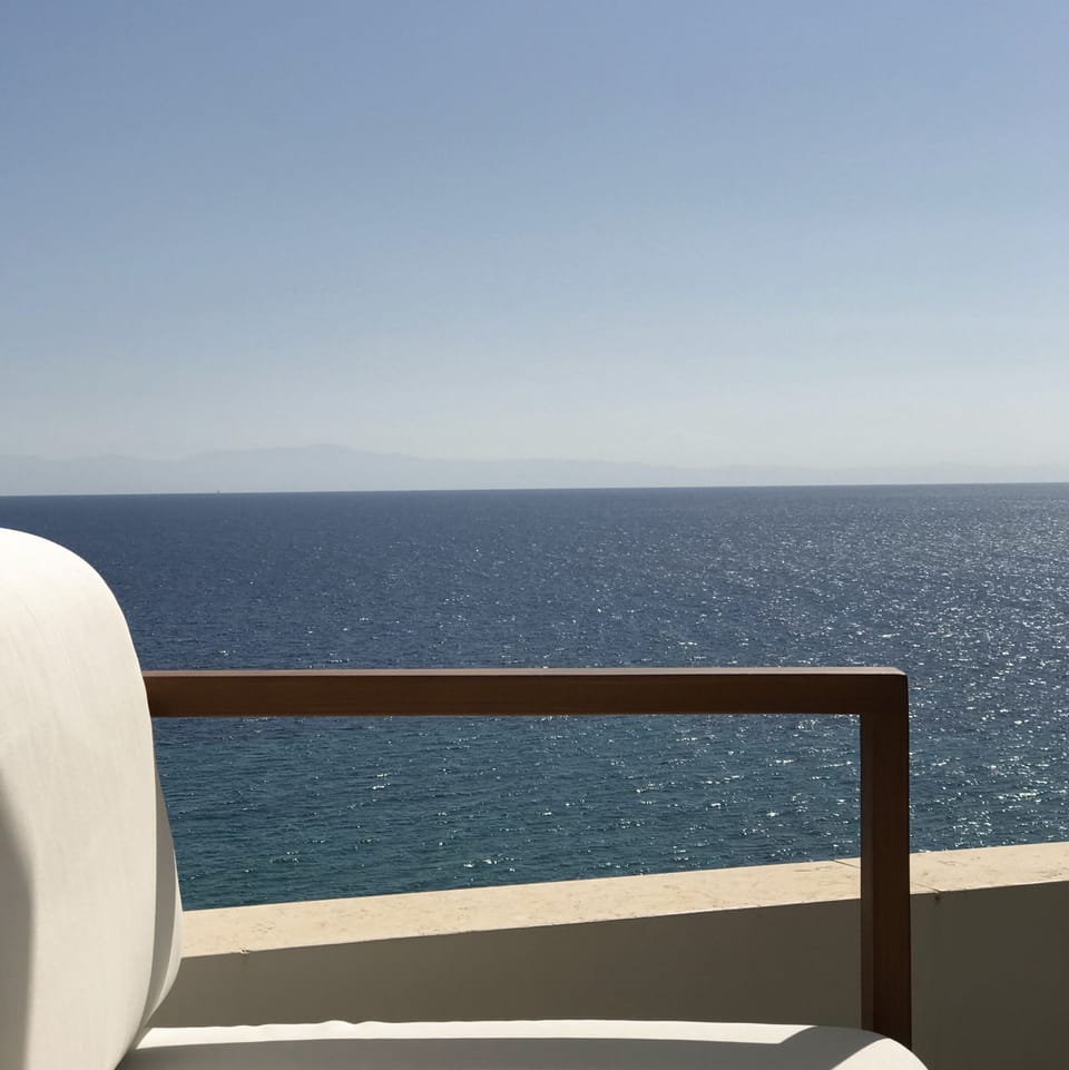 Sea view framed by terrace furniture and low parapet wall