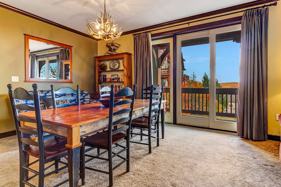 Dining space framed by wide windows overlooking the slopes.
