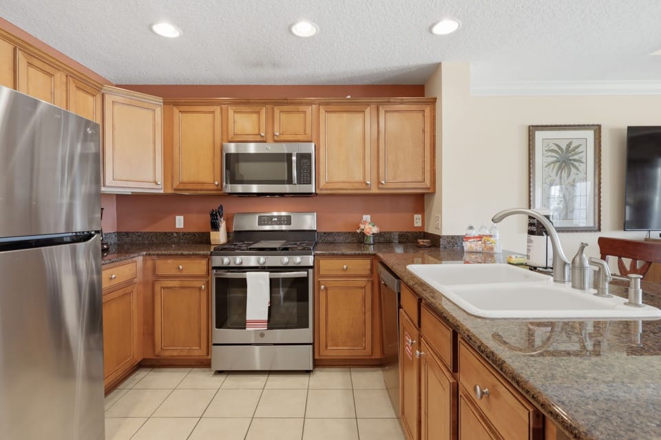 The open kitchen includes generous counter space and bar seating, making it easy to serve breakfast or chat while dinner is prepared.