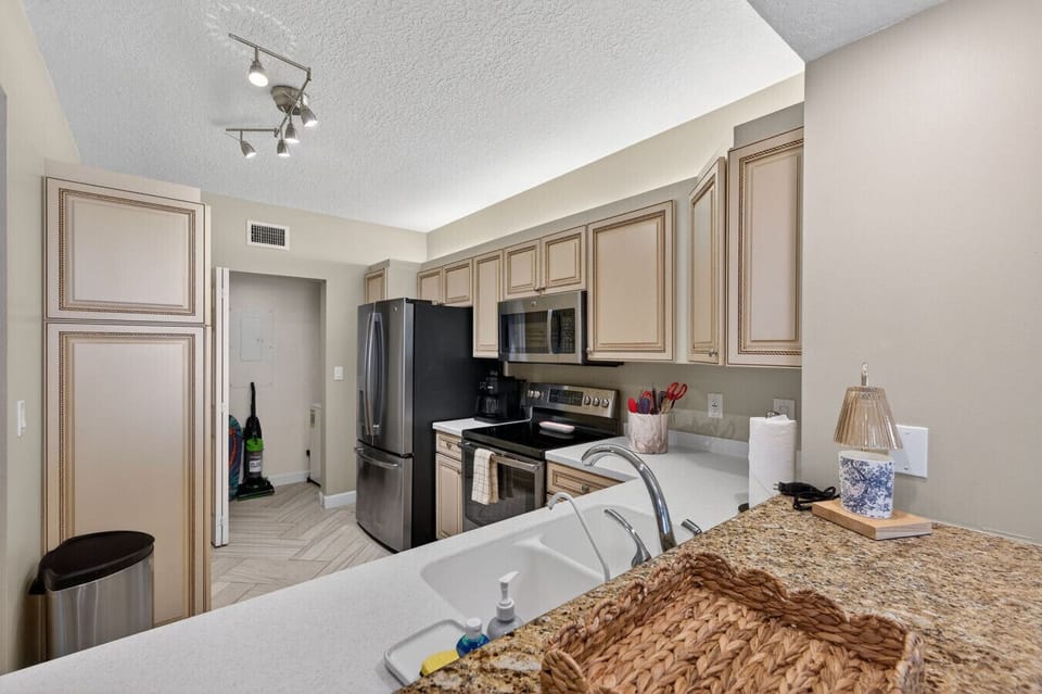 Fully equipped kitchen w/ modern appliances, generous counters & bar seating.
