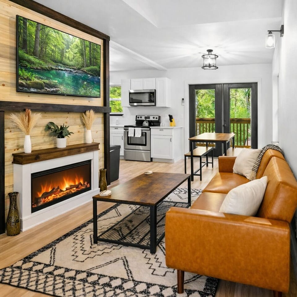 Cozy living room with fireplace, smart TV, and forest views