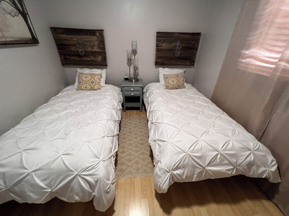 Guest bedroom 2 with two twin beds and tv. 