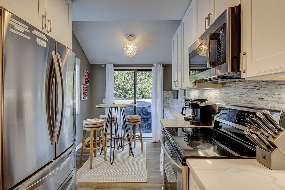 Fully stocked kitchen with stainless steel appliances. Also featuring a 2 seater high top.