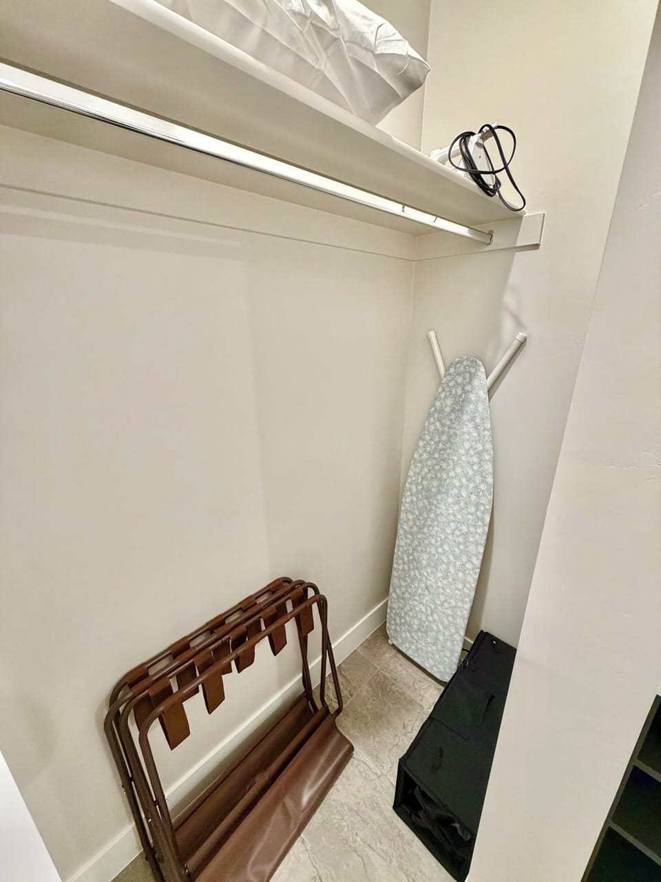 Closet in Bathroom 1 with ironing board, pack-n-play, luggage holders.