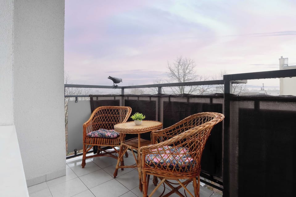 The furnished balcony creates a cozy spot for morning coffee or a moment of fresh air.