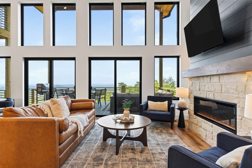 Relax beside the stone fireplace while two-story windows frame expansive mountain views.