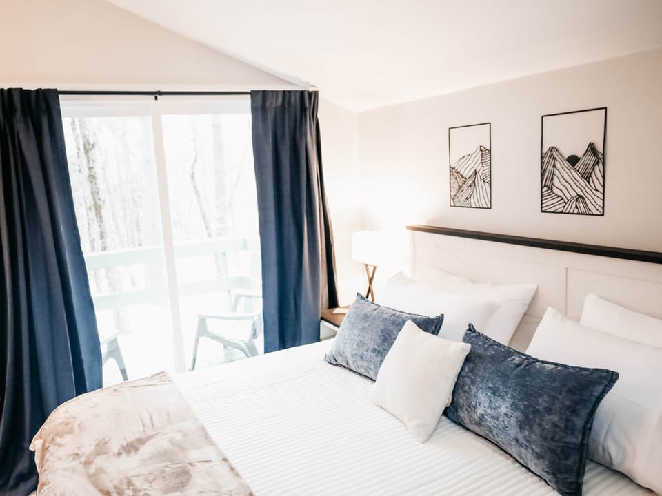 Peaceful primary bedroom with a king bed, soft lighting, and a calm, restful feel.