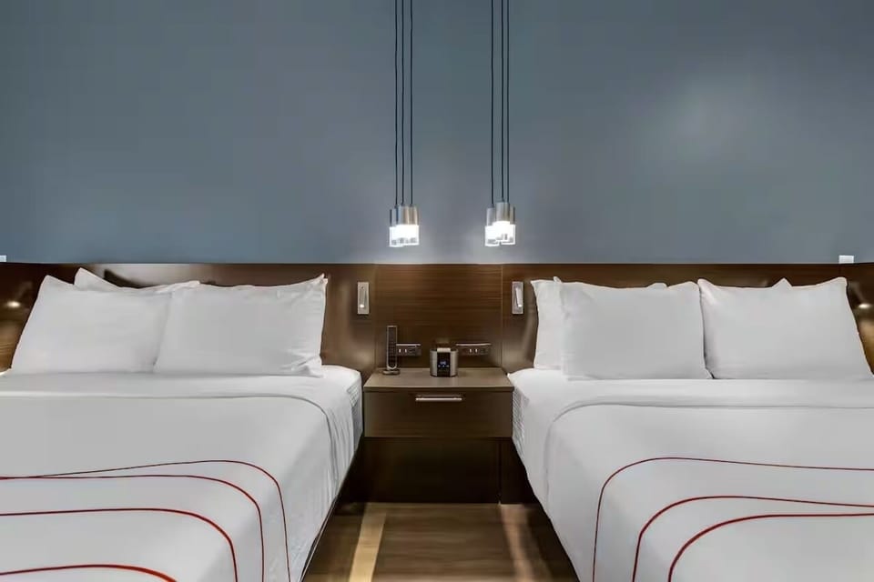 Sink into crisp linens between modern lighting and quiet comfort.