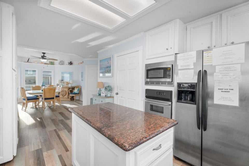 Open-concept kitchen and dining space with modern appliances, custom cabinetry, and seamless flow into the main living area of this beach house rental.