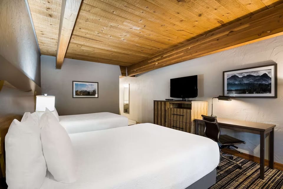 Unwind beneath rustic wood ceilings in crisp double-queen comfort.
