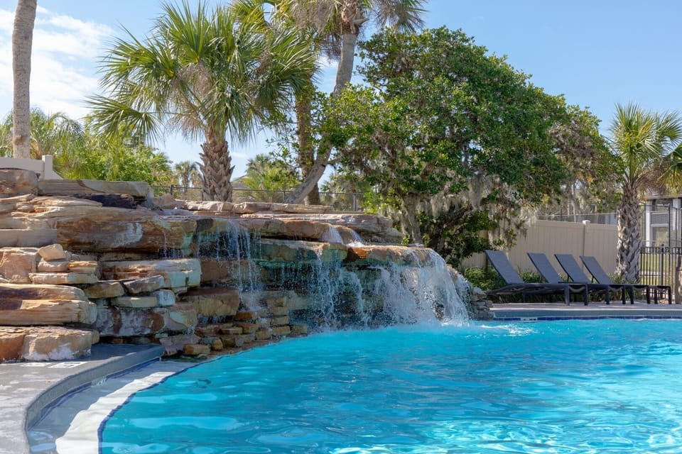 Dive into resort-style bliss beside a cascading rock waterfall.