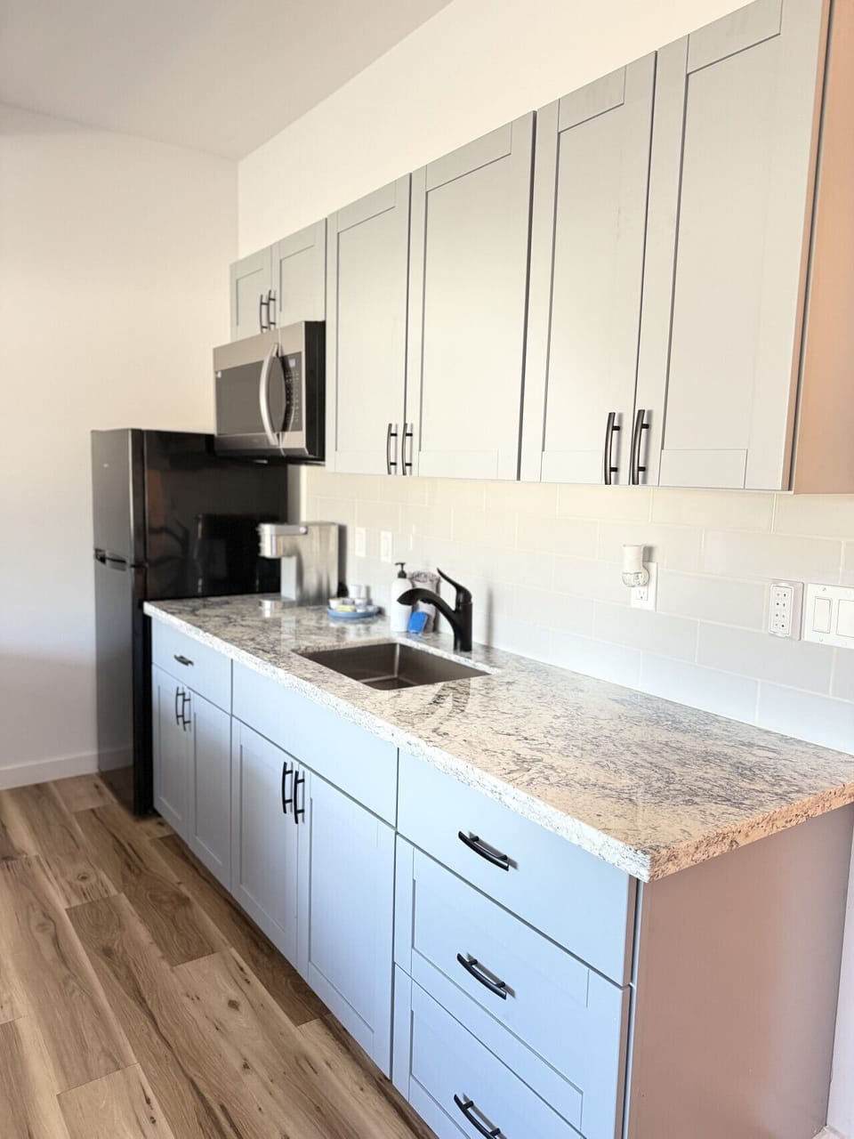 Kitchenette equipped with essential tools for preparing small meals. There is no stove or oven, but it includes a portable hot plate, skillet, and other basic cookware