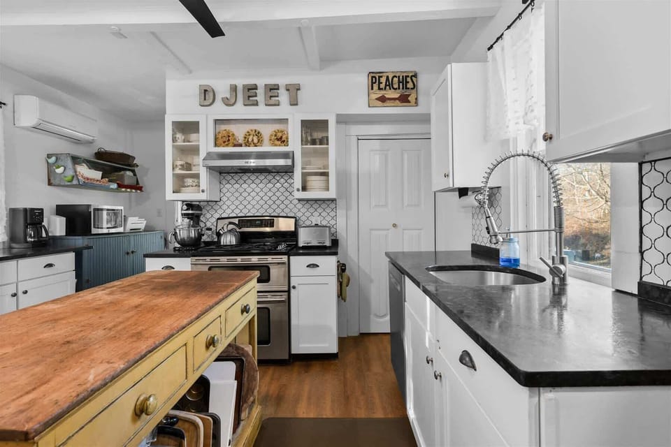 Fully equipped kitchen with range, deep sink, and ample prep space, perfect for easy Cape Cod meals at home.