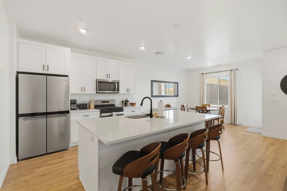 Bright open kitchen with large island, modern appliances, and bar seating.