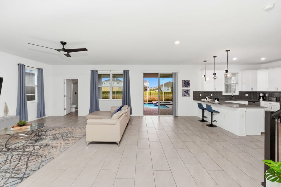 Open-concept living area with modern kitchen and pool access for relaxing gatherings.