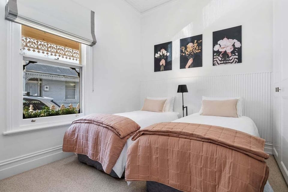BEDROOM 1: The front bedroom with streetc=scape outlook has twin single beds and a built in wardrobe.