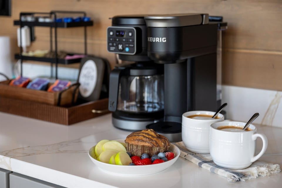 The dedicated coffee station offers both carafe and single-serve brewing with pods, mugs, and a staged breakfast.