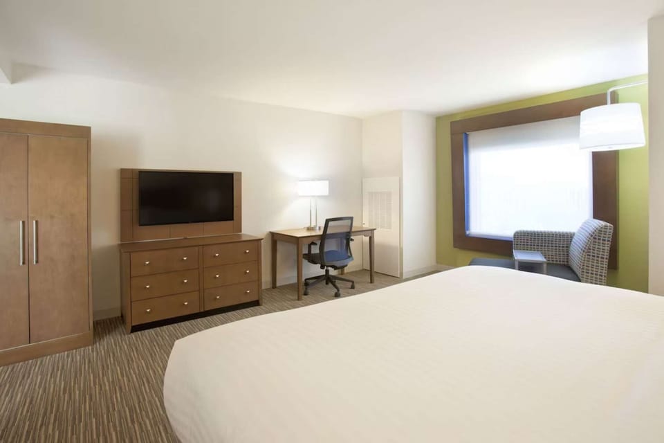 King room with desk, TV, and cozy window seating area