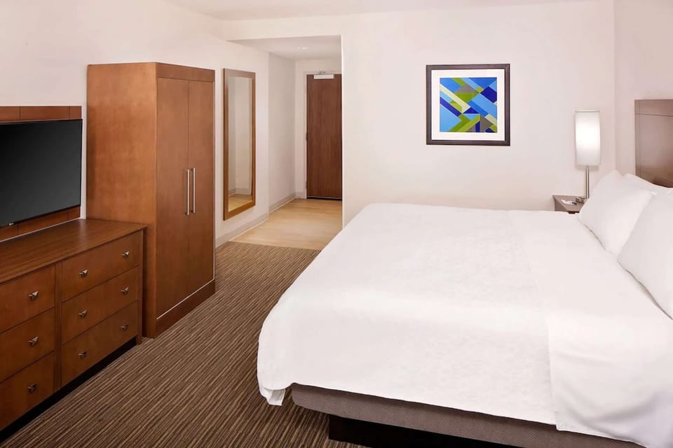 King room with warm wood furniture and full-length mirror