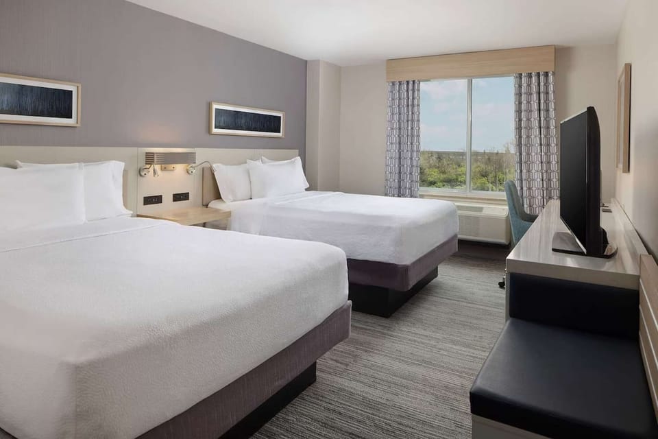 Double room with large window, desk, and relaxing seating area