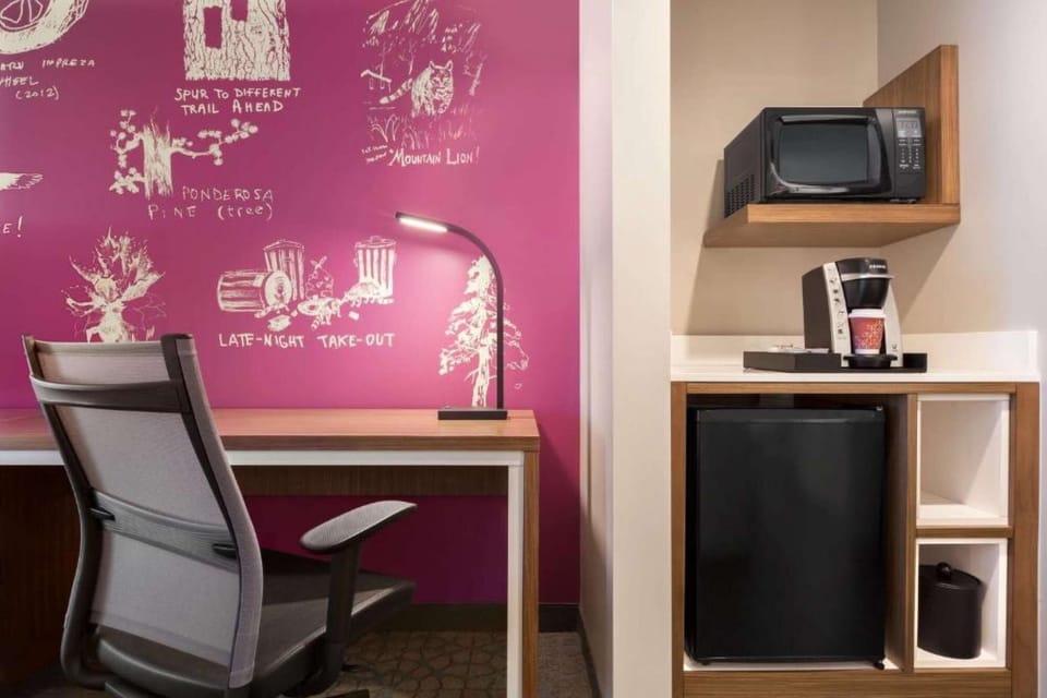 Workspace with magenta wall art, chair, and built-in appliances.